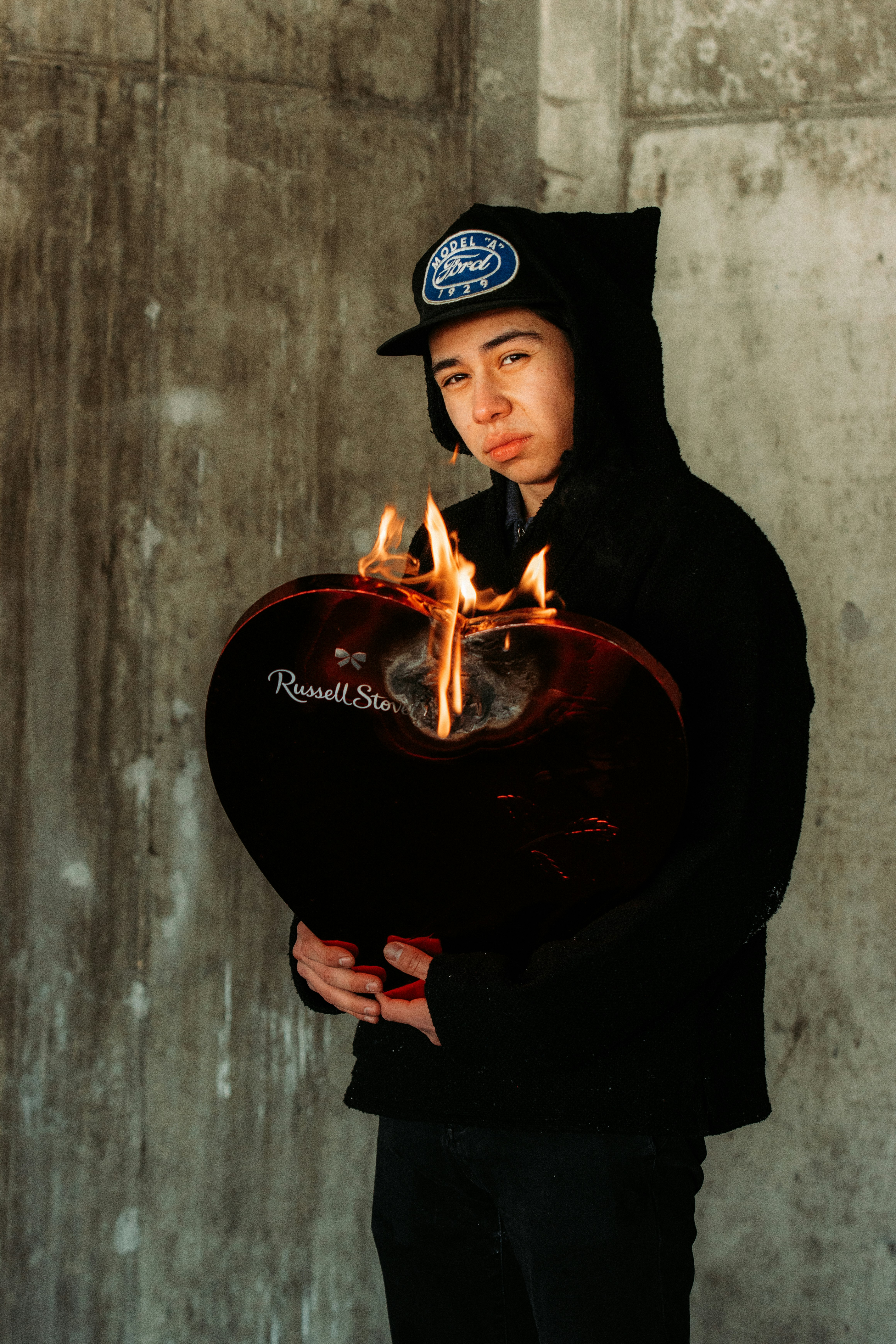 man in black hoodie holding fire